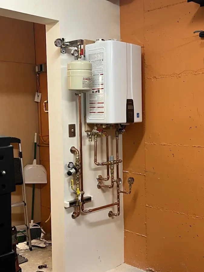 Plumbing technician inspecting water heater connections in Ramona